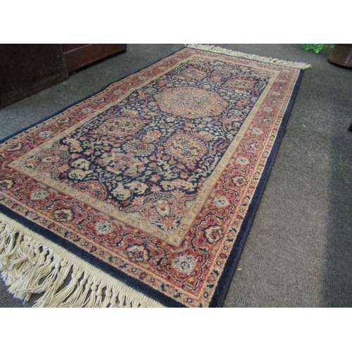 1018 - An Eastern wool blue ground floral design rug with tasselled ends, 135cm x 68cm