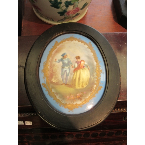 1101 - A painted oval porcelain plaque in the Sevres style, illustrating a dancing couple, framed, 21.5cm x... 