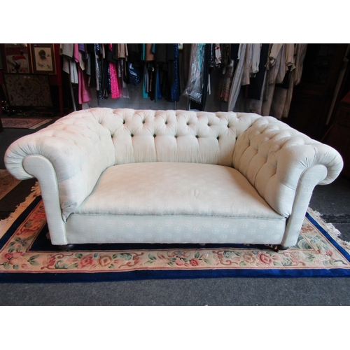 1015 - A Chesterfield fabric sofa on castors, signs of wear