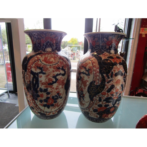 1182 - A pair of Japanese Imari pattern jugs, 31cm high