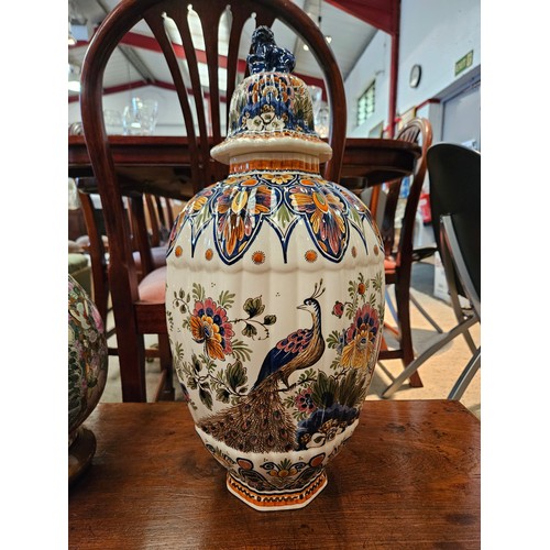 1080 - A Delft polychrome octagonal form vase with floral and peacock decoration, with lid having dog of fo... 