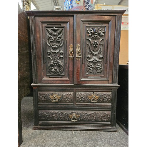 1121 - A late Victorian dark stained, carved oak two door cupboard over three small drawers, 75cm tall x 57... 