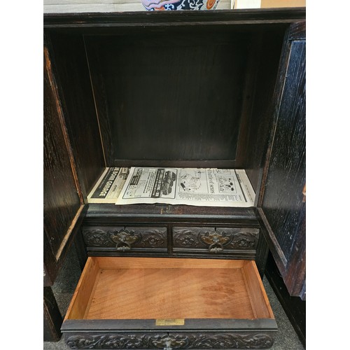 1121 - A late Victorian dark stained, carved oak two door cupboard over three small drawers, 75cm tall x 57... 