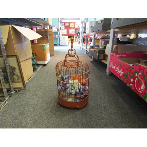 1415 - A bamboo wood bird cage containing faux flowers, 46cm tall overall height, a/f