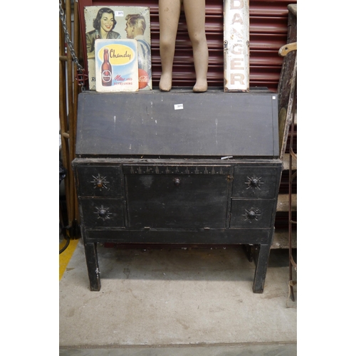 2072 - A rustic black painted pine bureau, one leg a/f