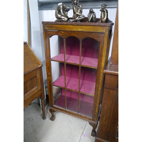 2123 - An 1920's oak glazed cabinet om cabriole ball and claw feet.  Red velvet interior, with key