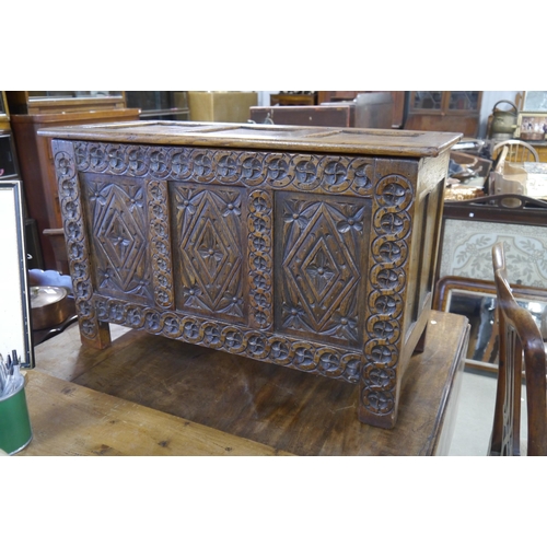 2203 - A heavily carved oak diminutive coffer, 47cm Tall x 76cm Width x 36cm Deep