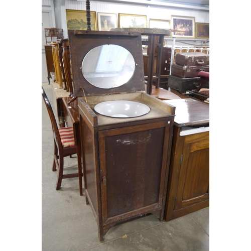 2212 - A 1930's oak mirrored washstand, enamel bowl and a mirror plate