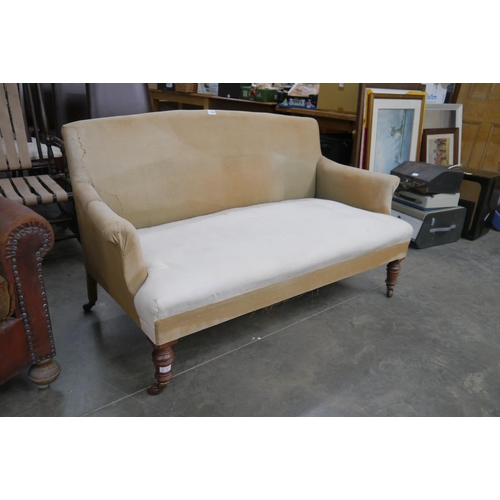 2362 - A Victorian walnut settee, turned legs to castors, for reupholstery