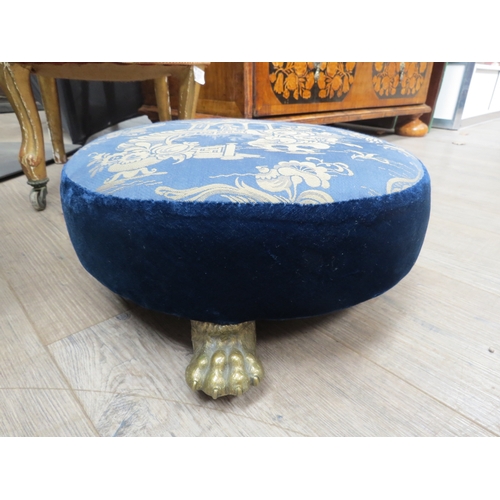 4213 - A 19th Century circular footstool with Chinese silk and velvet blue upholstery on ball in claw brass... 