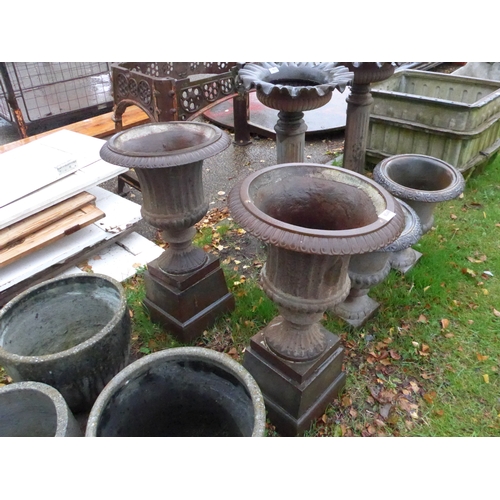 8049 - A pair of cast iron urns on stands, 67cm tall in total