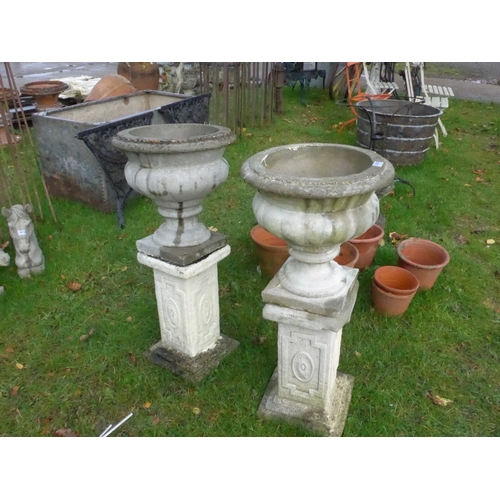 8130 - A pair of composition urns on plinths, 88cm tall in total