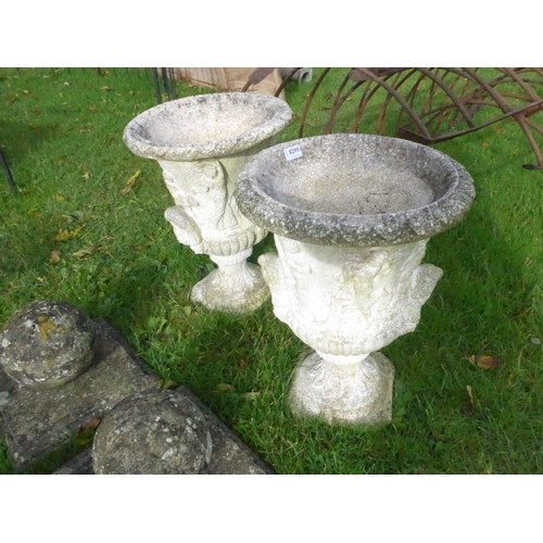 8290 - A pair of reconstituted  stone urn shaped planters with figural frieze decoration, 53cm tall