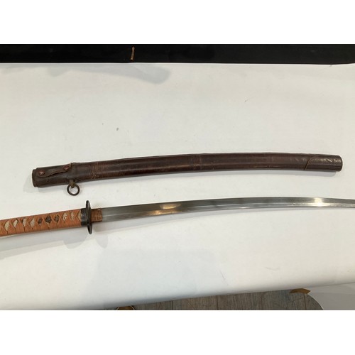 9372 - A Japanese katana, ray skin grip wrapped in cloth, iron tsuba with copper foliage, the tang unsigned... 