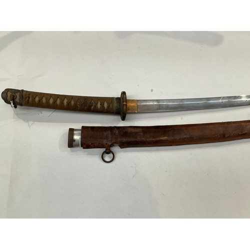 9373 - A WWII Japanese katana, the rayskin wrapped grip joining a bronze tsuba with floral relief, the blad... 