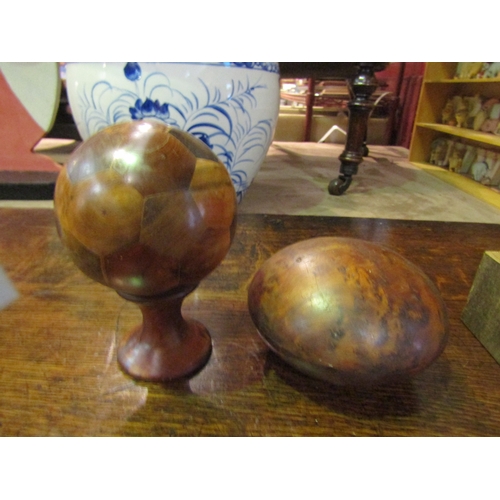 4024 - A burr wood lidded box, a wooden ball on stand with multiple wood types, together with another woode... 