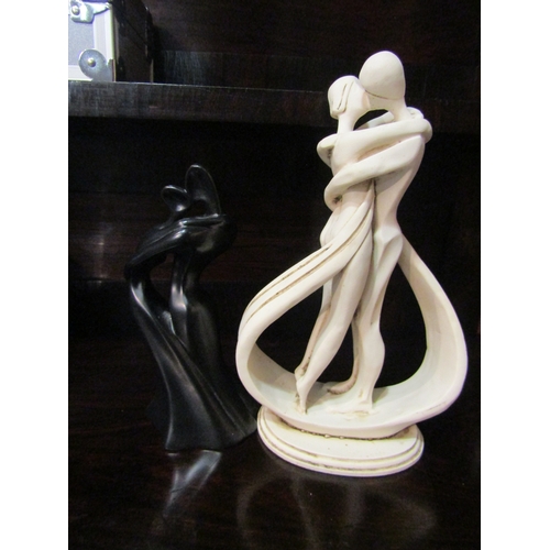 4029 - Two modernistic figures of couples embracing, 28cm and 22cm tall