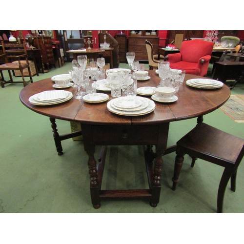 4110 - An 18th Century oak gateleg dining table the rising leaves over a single end cutlery drawer on turne... 