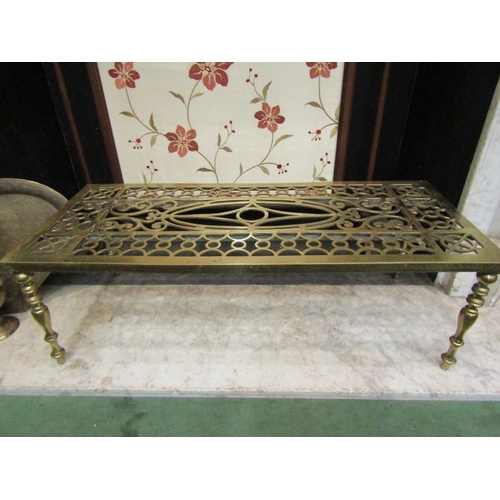 4161 - A large brass trivet on turned supports with pierced design, 24cm tall x 75cm long x 32cm wide