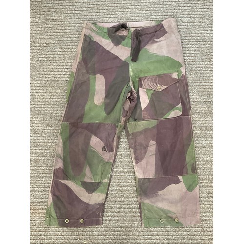 9051 - A pair of WWII 1944 dated British camouflage windproof trousers, some holing