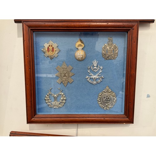 9061 - A framed collection of seven Scottish military hat badges