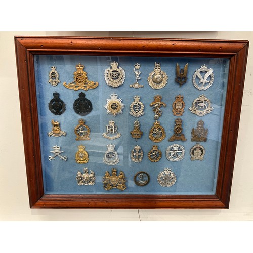 9062 - A framed collection of 32 military hat badges