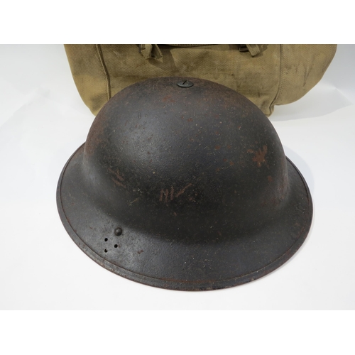 9203 - A WWII British Army helmet dated 1941, together with a WWII webbing kit bag (2)