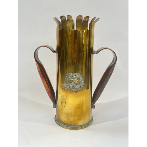 9380 - NORFOLK REGIMENT INTEREST: A WWI trench art shell case converted into a twin handled vase, with Norf... 