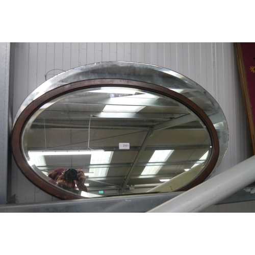 2501 - Two oak framed oval wall mirrors with a large unframed bevel-edged mirror glass (3)