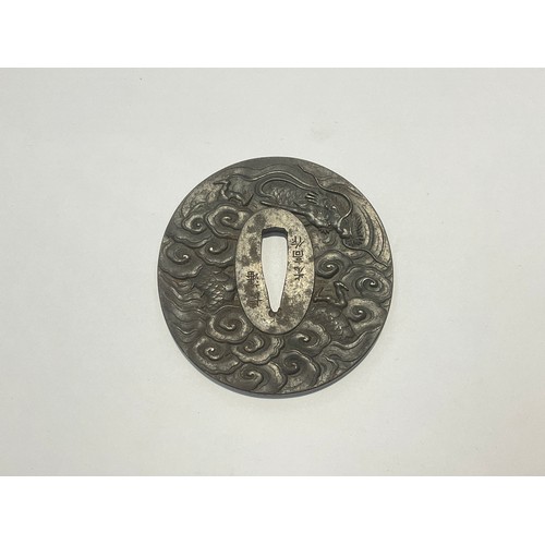 9538 - A Japanese iron tsuba, reputedly by Mitsutaka, signed. High relief of a dragon, 75mm x 72mm