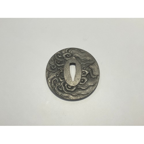 9538 - A Japanese iron tsuba, reputedly by Mitsutaka, signed. High relief of a dragon, 75mm x 72mm