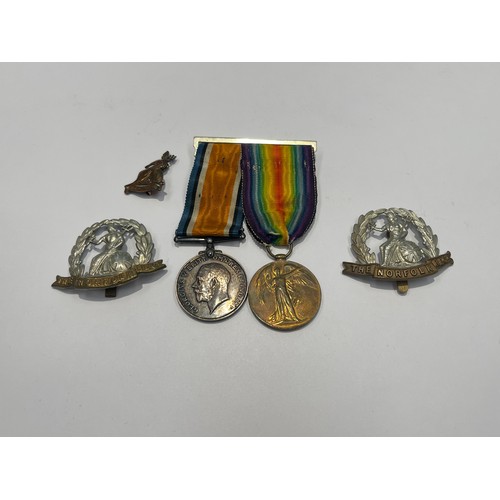 9550 - A WWI pair of medals named to 27339 A. CPL. N.D. HANTON NORF. R. together with two cap badges, a cop... 