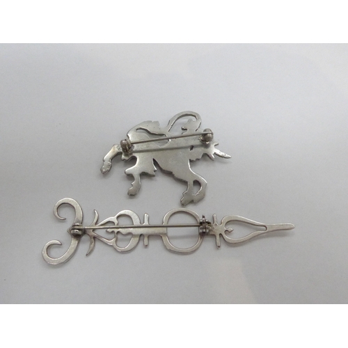 7327 - A Mid Century white metal leaping Unicorn brooch and a Scandi style white metal skeletal key brooch.