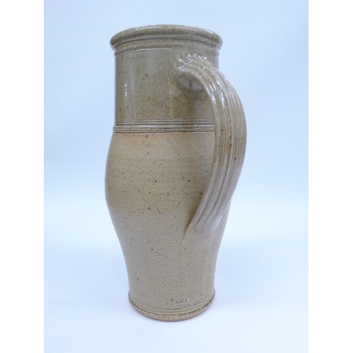 7082 - An A. & J. Young large stoneware jug with oatmeal glaze.  Impressed Gresham mark. 32cm high.