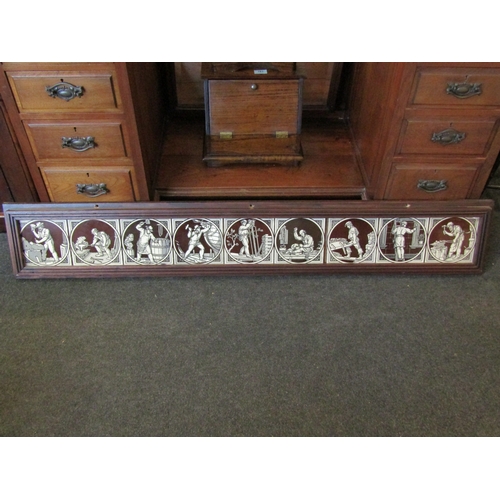 1011 - An oak framed set of nine Maw & Co. tiles depicting craftspeople, 146cm long