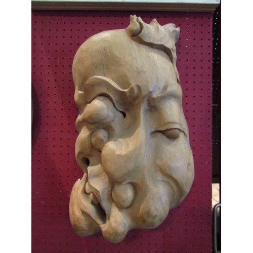 1057 - An Eastern carved abstract wall mask, 45cm tall