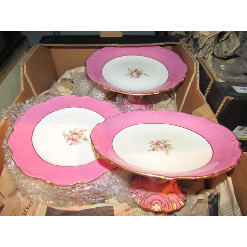 1075 - Two boxes containing a porcelain transferware part dessert set with pink borders and floral design, ... 