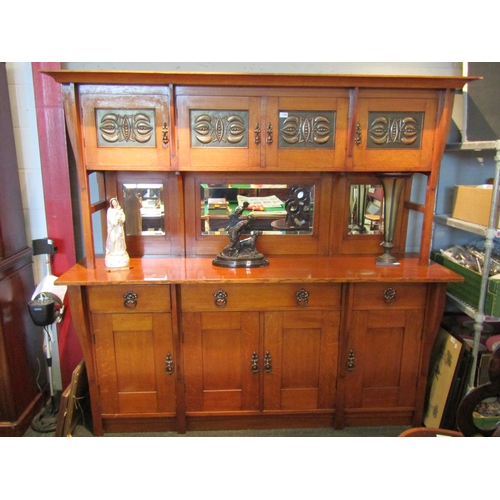 1080 - An Arts & Crafts oak sideboard with raised mirrored back, four cupboard doors with copper panels ove... 