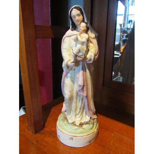 1083 - A Staffordshire figure of Mary holding baby Jesus, 35cm tall, heavily crazed