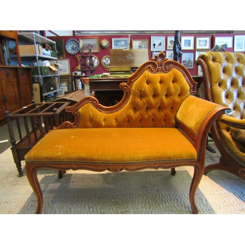 1092 - A chaise longue of small proportions, mustard upholstery with brass stud detailing and button back, ... 