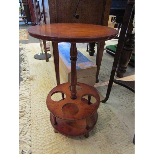 1101 - A 20th Century burr wood effect wine table with four bottle holder, 57cm tall