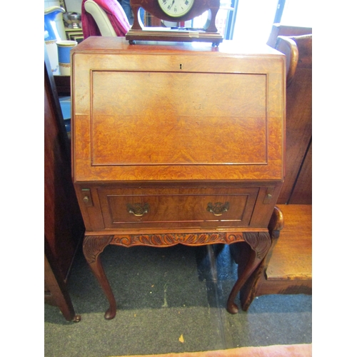 1141 - A burr walnut veneer bureau, drop-flap over single drawer flanked by brushing slides, cabriole legs ... 