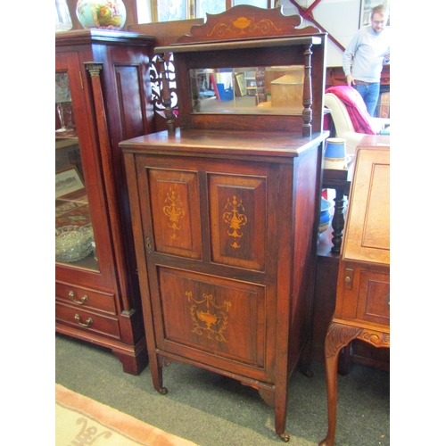 1143 - An Edwardian mahogany music cabinet, single cupboard door with raised mirrored back, on castors, 134... 