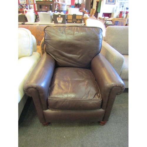 1191 - A Derwent brown leather armchair with scrolled arms