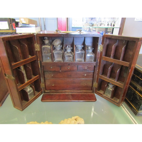 1475 - A mahogany doctor's cabinet with various bottles and internal drawers, ivory handles removed