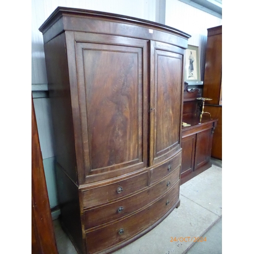 2105 - A 19th Century mahogany bow-fronted linen cupboard on two over two drawer chest