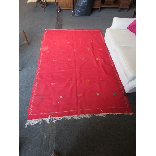 1028 - A Moroccan red ground wool rug, stained, 244cm x 155cm