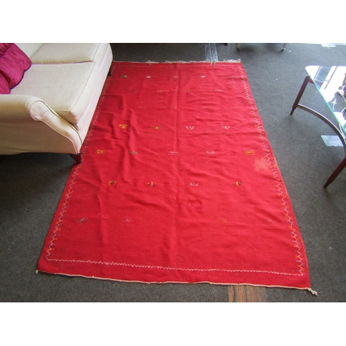 1028 - A Moroccan red ground wool rug, stained, 244cm x 155cm