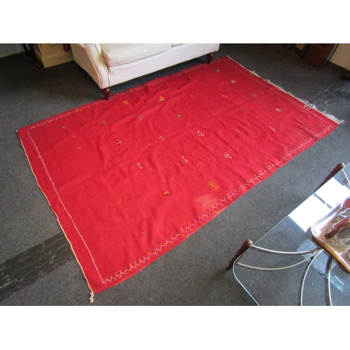 1028 - A Moroccan red ground wool rug, stained, 244cm x 155cm