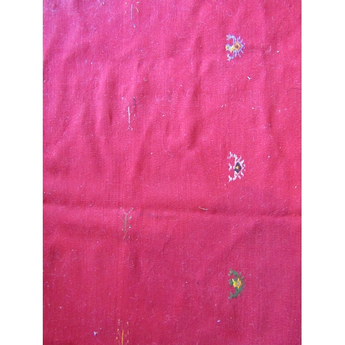 1028 - A Moroccan red ground wool rug, stained, 244cm x 155cm